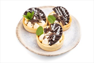 Sweet tartlets with chocolate and cheese cream isolated on white background. Side view, close up