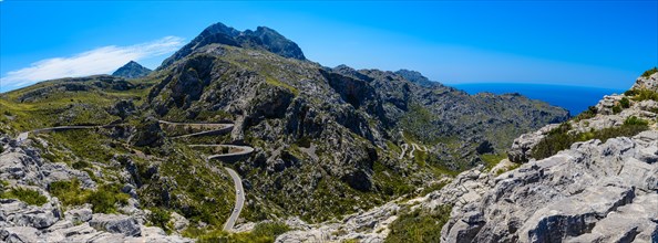 Panoramic shot of a winding mountain road with blue sky and sea in the background, Majorca