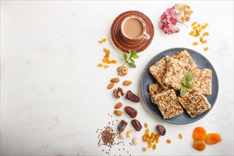 Homemade granola from oat flakes, dates, dried apricots, raisins, nuts in blue ceramic plate with a