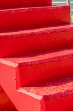 Closeup of red concrete stairs in bright afternoon sunlight in South Korea