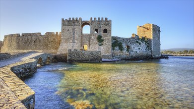 Old castle walls reflected in the water with sea view in the background, sea fortress Methoni,