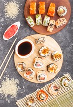 Different kinds of maki sushi rolls with salmon, sesame, cheese, roe and chopsticks, soy sauce,