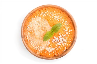 Carrot cream soup with sesame seeds in wooden bowl isolated on white background. top view, flat