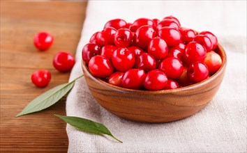 Fresh red sweet cherry in wooden bowl on wooden background. side view, close up