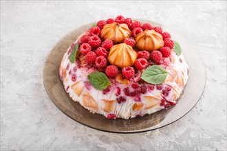 Homemade jelly cake with milk, cookies and raspberry on a gray concrete background. side view,