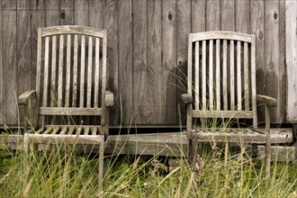 2 wooden chairs in front of a natural wooden wall of a fisherman's hut, Hvide Sande, Midtjylland