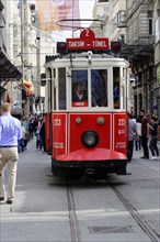 Historic tram Nostaljik Tramvay travelling through Istiklal Caddesi shopping street, Beyoglu,