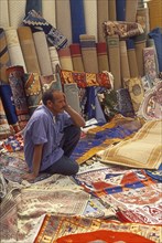 Resting carpet seller at market in Torre del Mar, Andalusia, Spain, Southern Europe. Scanned