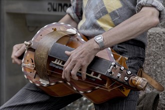 Man playing a hurdy-gurdy, Dinan, Brittany, France, Europe
