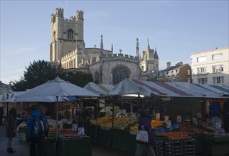 Historic tower of Great St Mary's church and market stalls in the city centre, Cambridge, England,