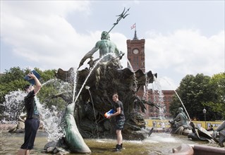 Water-hungry participants of this year's water fight at Berlin's Neptune Fountain cool off in