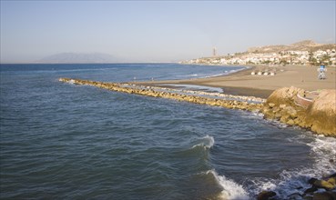 Coastline with breakwater groyne, waves and beach at La Cala del Moral, Malaga, Spain, Europe