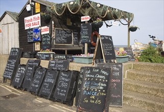 Blackboard offers for fresh fish on sale outside beach shed, Aldeburgh, Suffolk, England, United