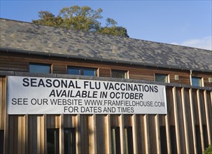 Seasonal flu vaccinations available poster sign on Framfield health centre, Woodbridge, Suffolk,