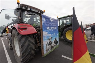 Poster with dairy cows and writing Systemrelevant on a tractor, farmer protests, demonstration