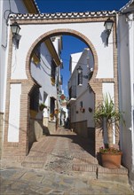 Moorish archway architectural feature and alleyway in the Andalusian village of Comares, Malaga