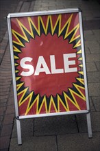 Close up of street shop Sale poster standing on pavement