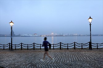 A woman jogs in the morning near the Royal Albert Dock in Liverpool, 01/03/2019