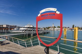 Excursion boat St. Gallen and advertising sign Grand Tour of Switzerland in the harbour,