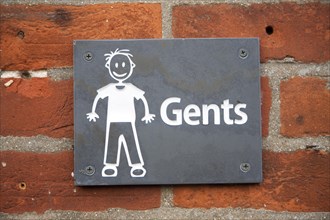 Drawing sign white figure on black slate for Gents toilets, UK