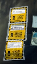 Three penalty charge parking notice tickets on car windscreen