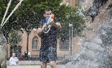 Participants in the annual water fight at Berlin's Neptune Fountain cool off in summer