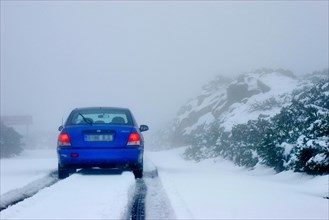Blue rental car in the snow of the highest mountain Roque de los Muchachos altitude 2400 m, La