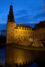 Photo in blue hour with view of castle tower of moated castle Raesfeld in southern Muensterland, in