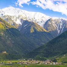 View of the village of Morter with the mountains of the Stelvio National Park behind it, evening