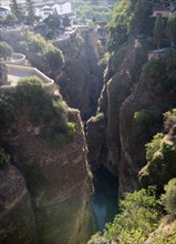 El Tajo canyon of the Rio Guadalevin river with white buildings perched on the cliff top, Ronda,