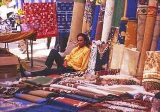 Resting carpet seller at market in Torre del Mar, Andalusia, Spain, Southern Europe. Scanned