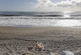 A man sunbathes on the deserted beach of Torremolinos, Spain, Costa del Sol, 13/02/2019, Europe