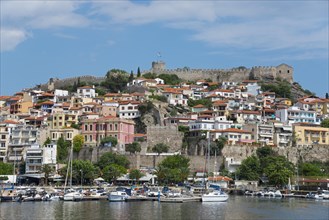 A marina with colourful houses and an ancient castle under a partly cloudy sky, fortress, old town,