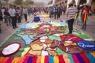 Peruvian couple making a floor painting in the Plaza de Armas, spectators watching, Ayacucho,