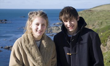 Model released brother and sister twins standing together on sunny winter day, Cornwall, England,