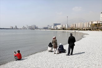 A family on the beach of Lake Chitgar in Tehran, Iran. Lake Chitgar is a man-made lake in the