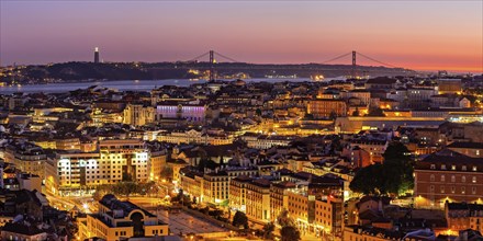 Panoramic picture of the sunset at a viewpoint in Lisbon with a view of the illuminated old town,