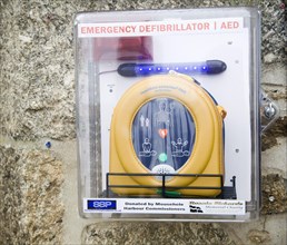 Emergency Defibrillator for public emergency use mounted on a wall, Mousehole, Cornwall, England,
