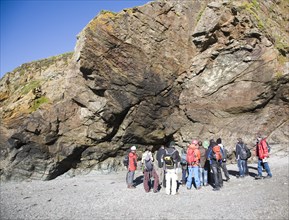 Student group of geologists on a fieldtrip at Polpeor Cove, Lizard Point, Cornwall, England, United