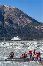 Passengers of the cruise ship Stella Australis land in a rubber dinghy between ice floes on the Pia