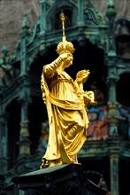 Statue of Maria Mary with Jesus in front of the Glockenspiel of New Town Hall Marienplatz, Munich,