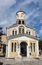 Facade of an orthodox church with a bell tower and Greek flag, Holy Church of the Assumption, Old