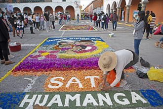 Peruvian woman making a floor painting in the Plaza de Armas, spectators watching, Ayacucho,