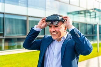 Happy businessman putting on virtual reality headset outside a financial building