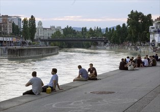 People relaxing in summer temperatures on the banks of the Danube Canal in Vienna, 19 July 2019