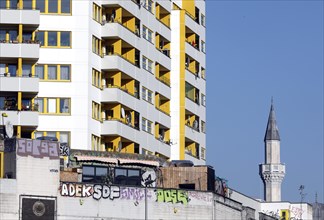 Minaret of the Mevlana mosque next to a high-rise building in Berlin's Kreuzberg district, 12