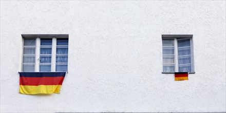 A large and a small German flag are attached to the windowsill of a house in Berlin, 20 June 2018