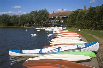 Colourful rowing boats on the Meare boating lake, Thorpeness, Suffolk, England, United Kingdom,