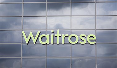Dark clouds reflected in glass surface of Waitrose store, Ipswich, Suffolk, England, United