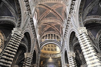 Black and white striped marble columns in the cathedral, cross and round arches, Siena, Tuscany,